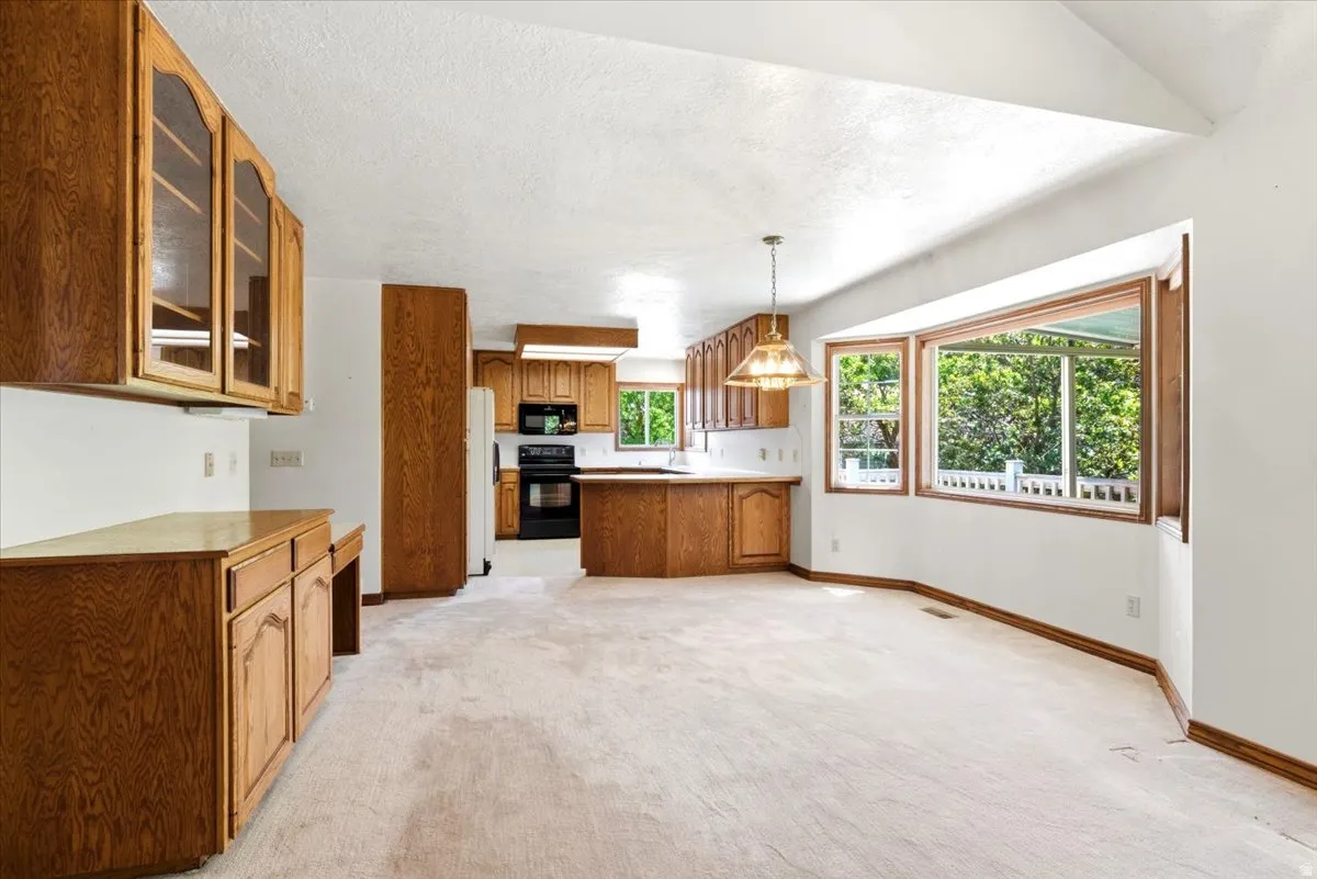 Open-concept living space featuring wood-finish cabinetry, a built-in desk area, and a kitchen island