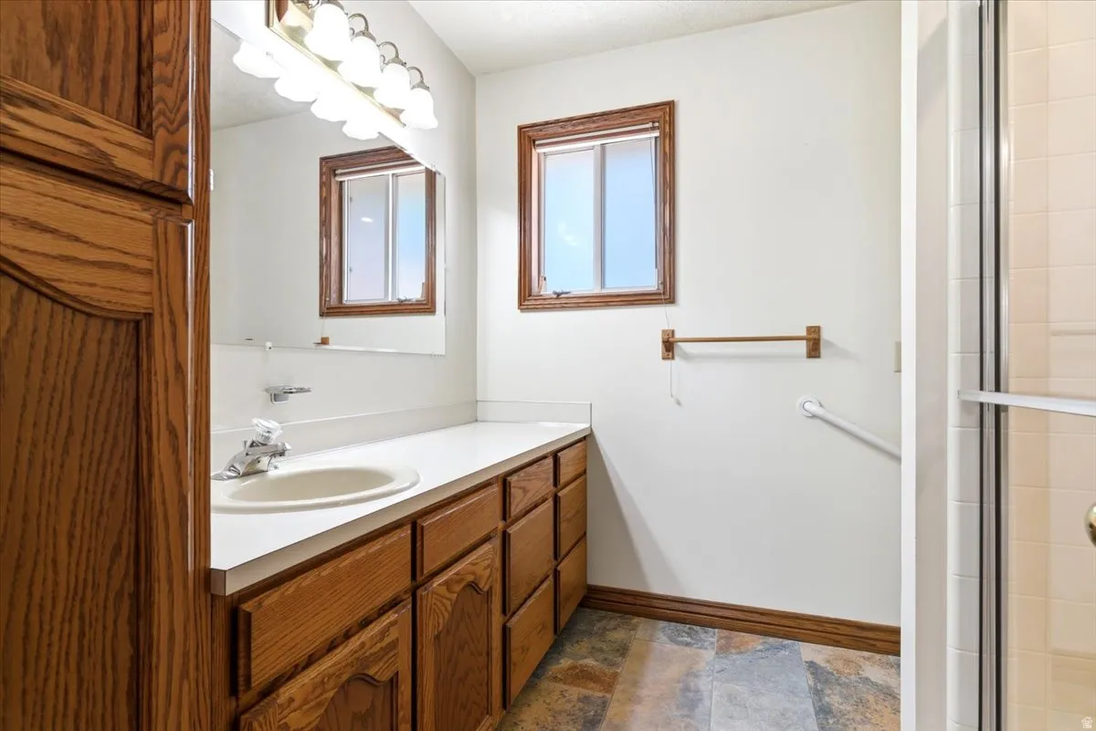 Bathroom featuring a single vanity with wood-finish cabinetry and a white countertop
