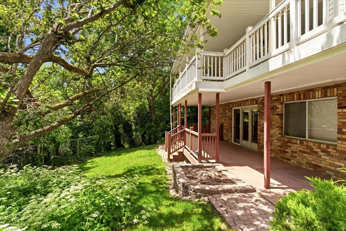 Brick exterior featuring a lower-level deck with wooden posts and railings