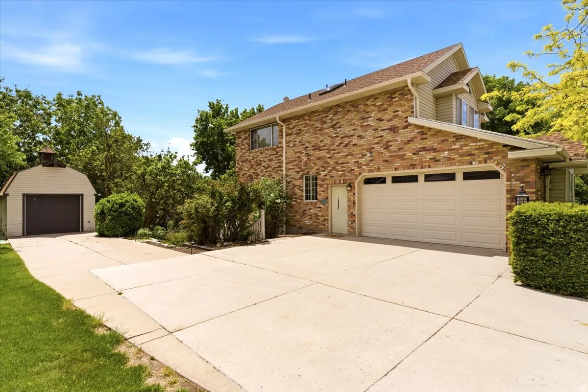Brick exterior featuring a two-car garage with paneling and upper window inserts