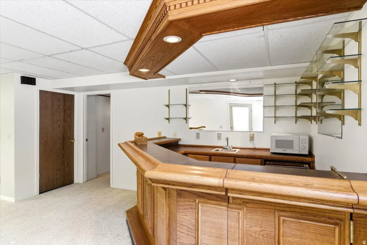 Custom bar area featuring a wood-finish bar, integrated sink, and ample counter space
