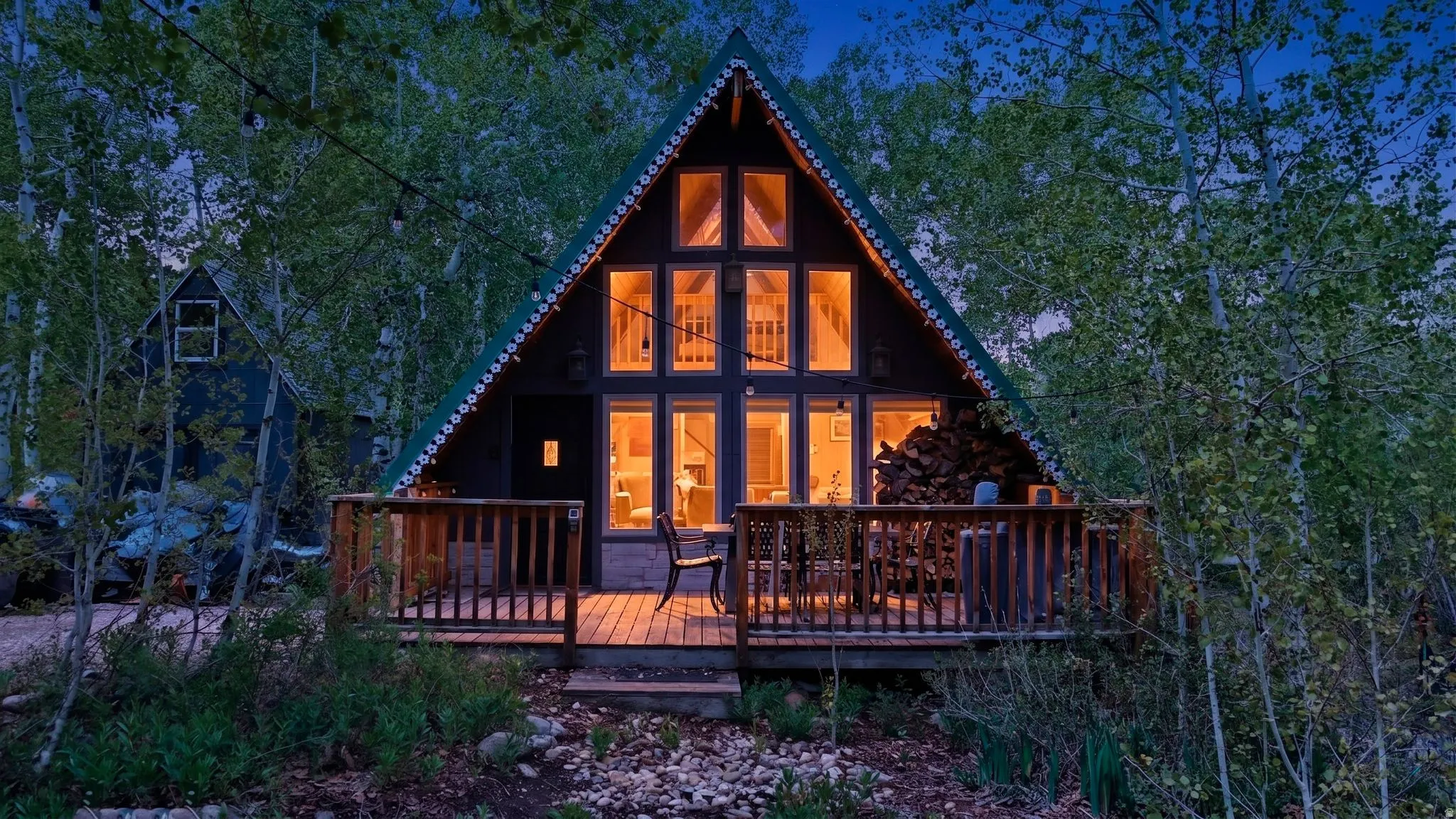 A-frame residence featuring a prominent pitched roofline and an expansive front deck