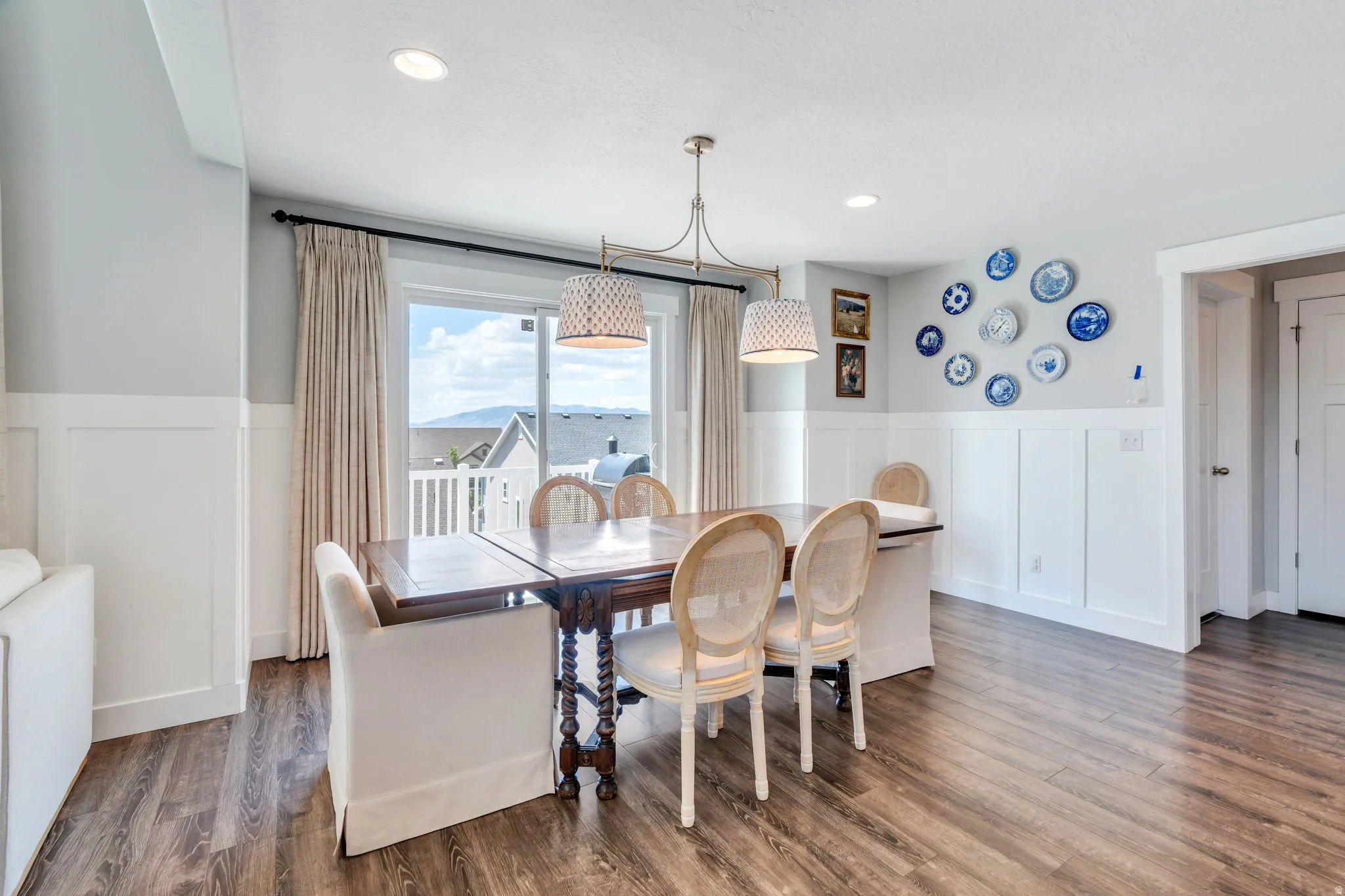 Dining space featuring wood-finish flooring, white wainscoting, and recessed lighting