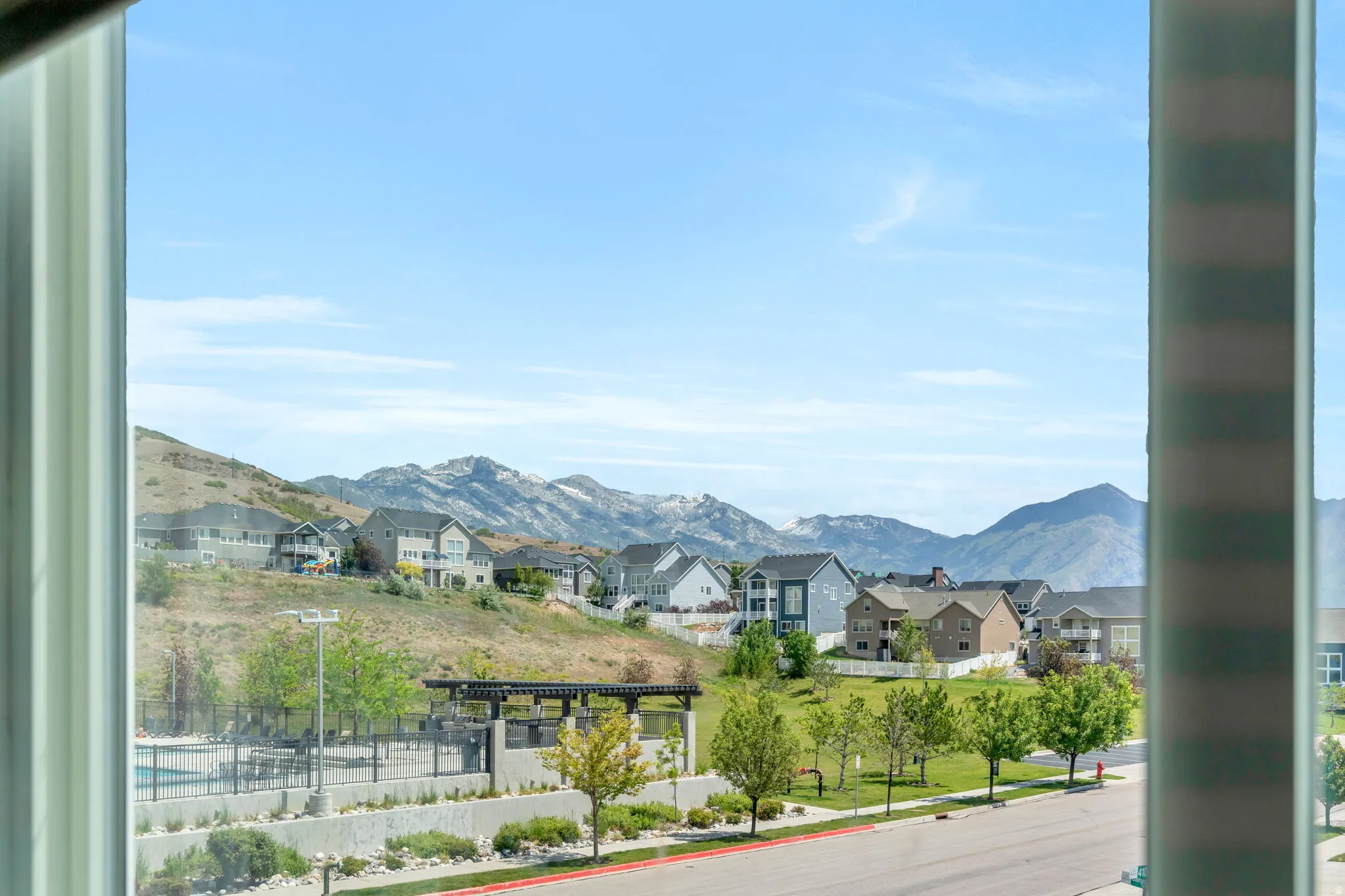Expansive mountain and community landscape through a large window frame