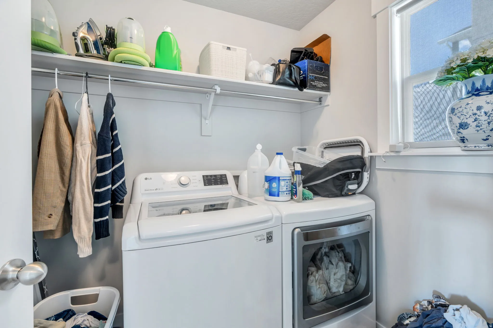 Dedicated laundry area featuring a window, built-in shelving, and a clothing rod