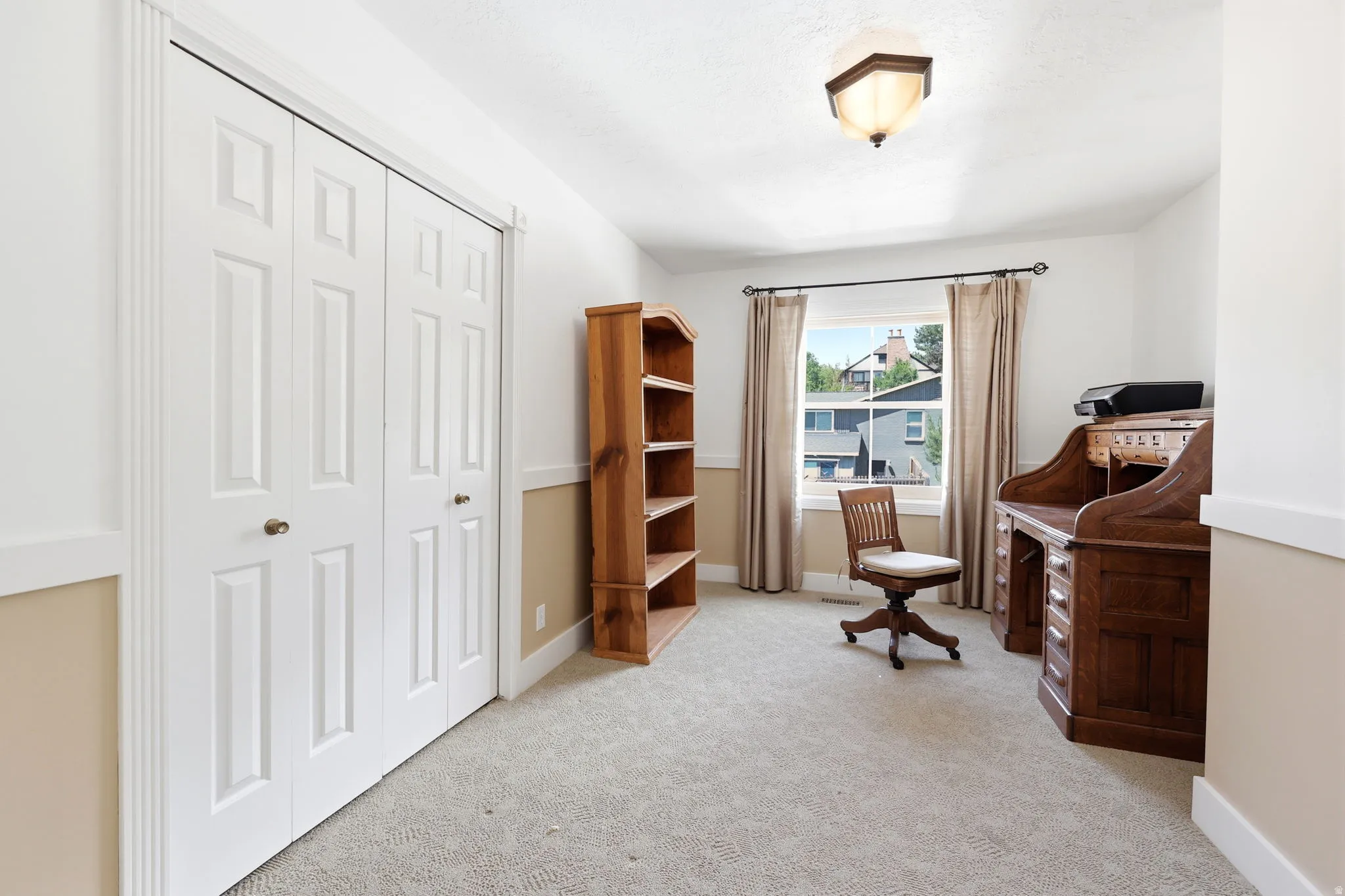 Room featuring neutral carpeting, a window with exterior views, and a ceiling-mounted light fixture