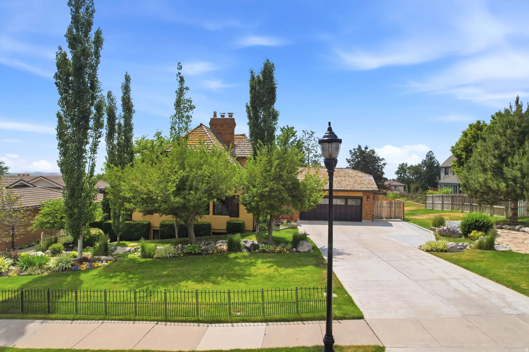 Residence featuring a cedar shake roof, brick chimney, and stucco exterior
