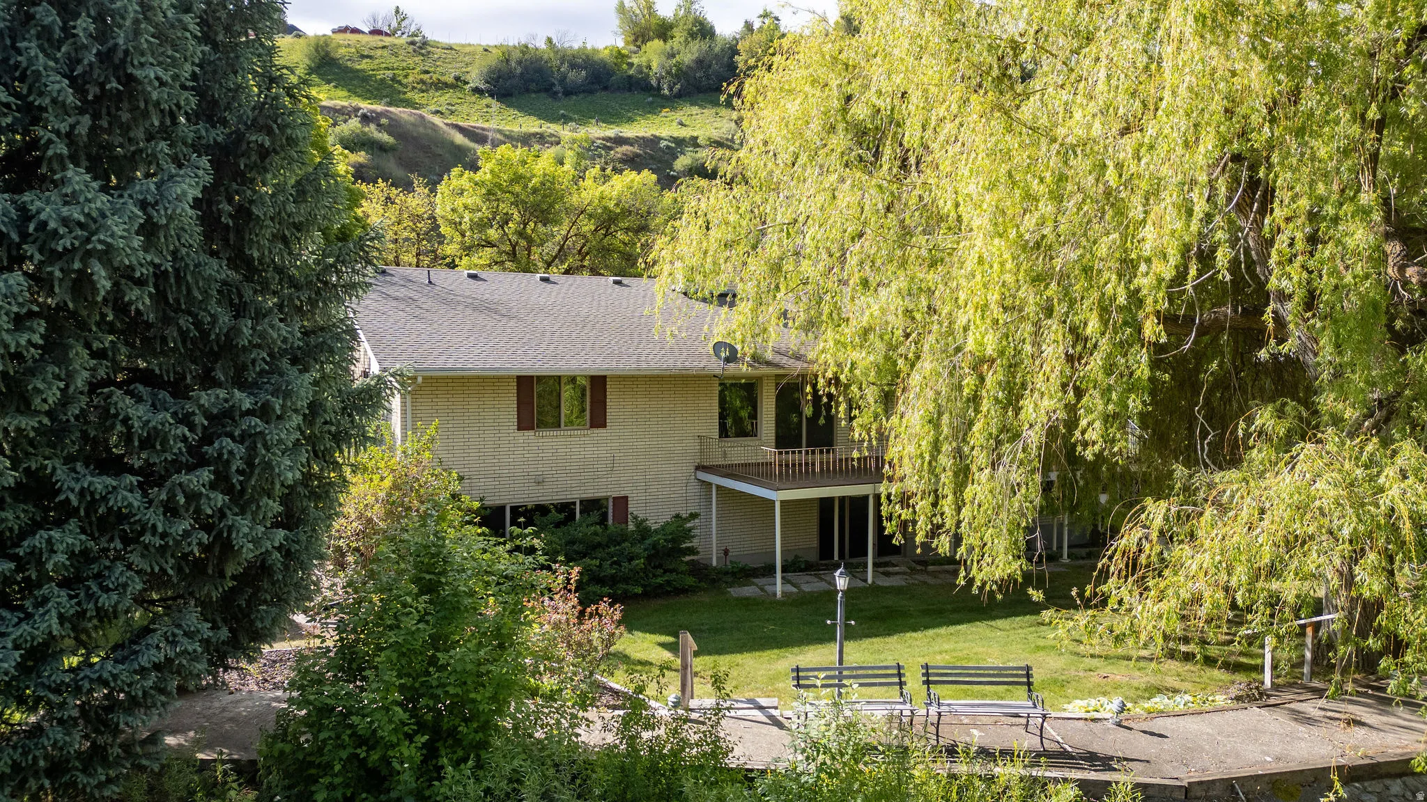 Rear exterior with a second-story balcony and ground-level patio