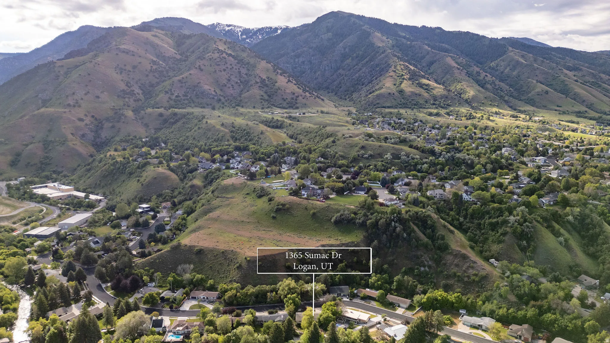 Aerial perspective showcasing a residential neighborhood nestled within a mountainous landscape