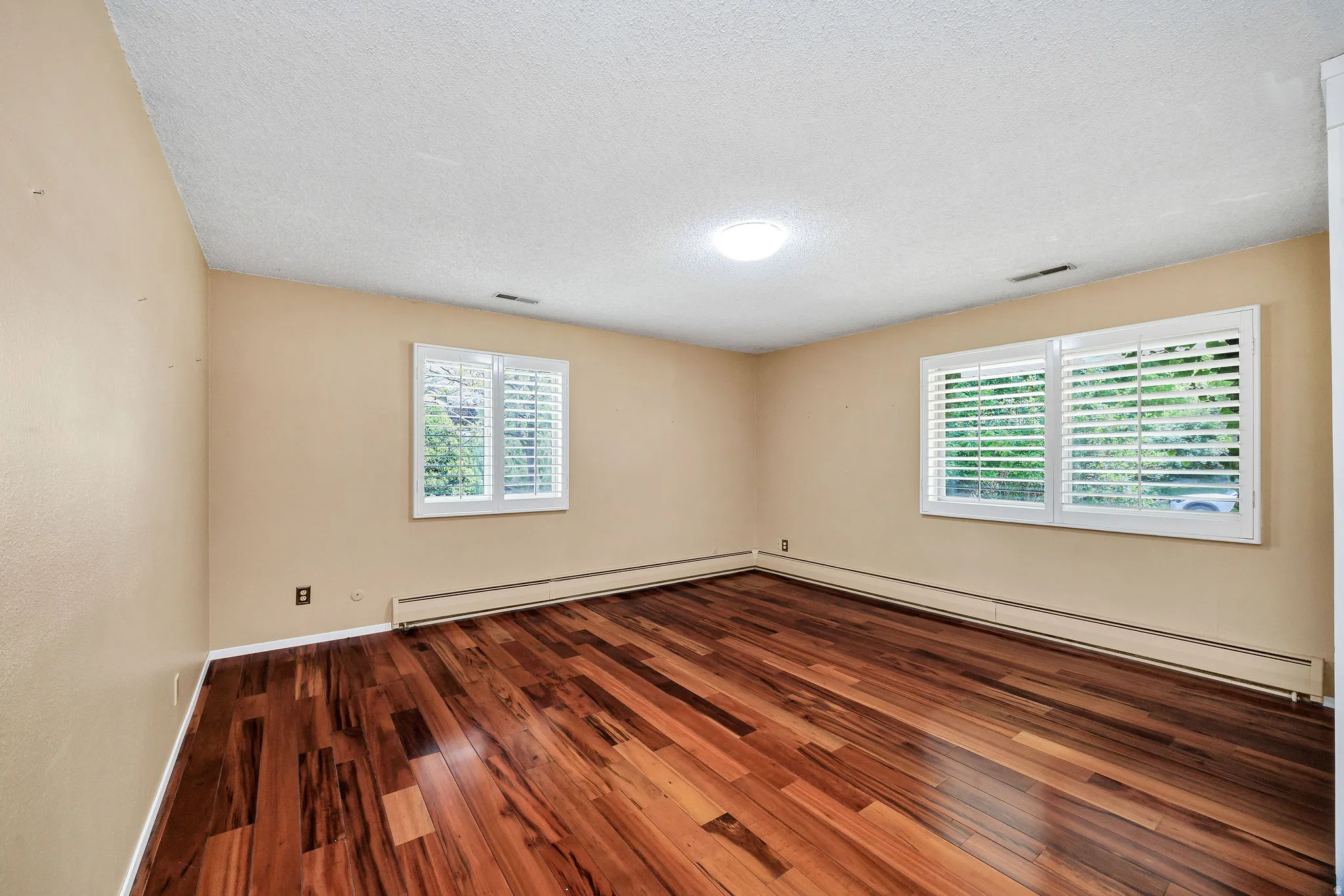 Rich wood-finish flooring provides a striking contrast with the neutral wall tones