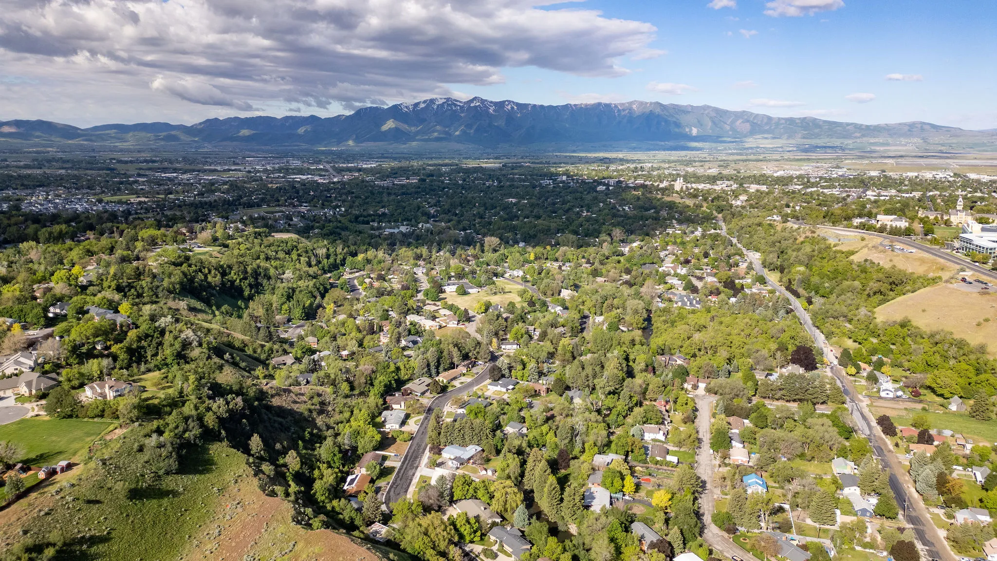 Expansive aerial perspective showcasing a residential landscape set against a mountain range backdrop