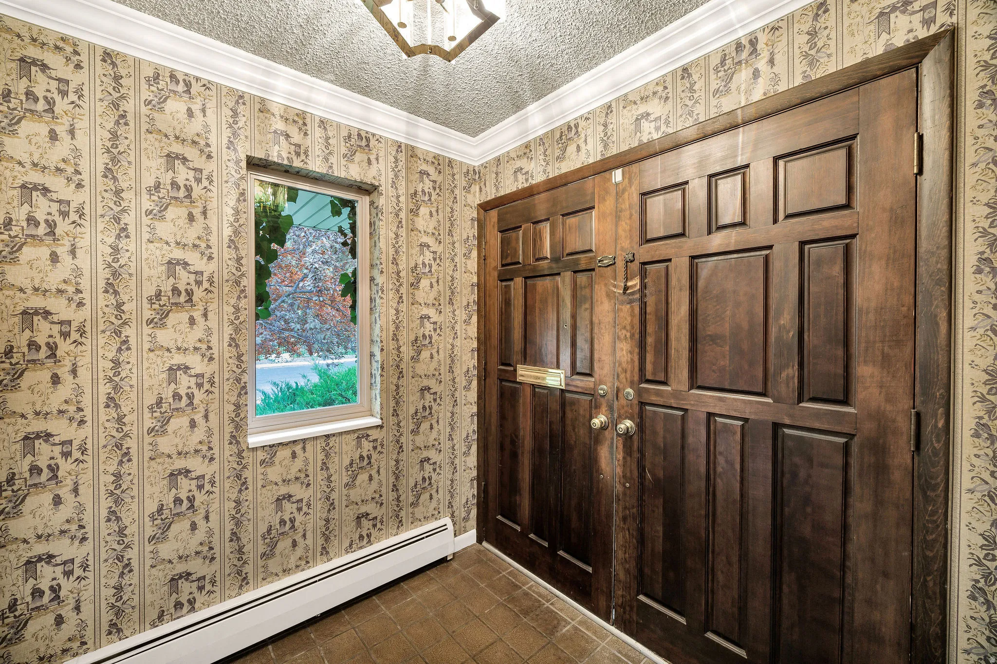Double entry doors with panel details, a decorative ceiling fixture, and a single-pane window