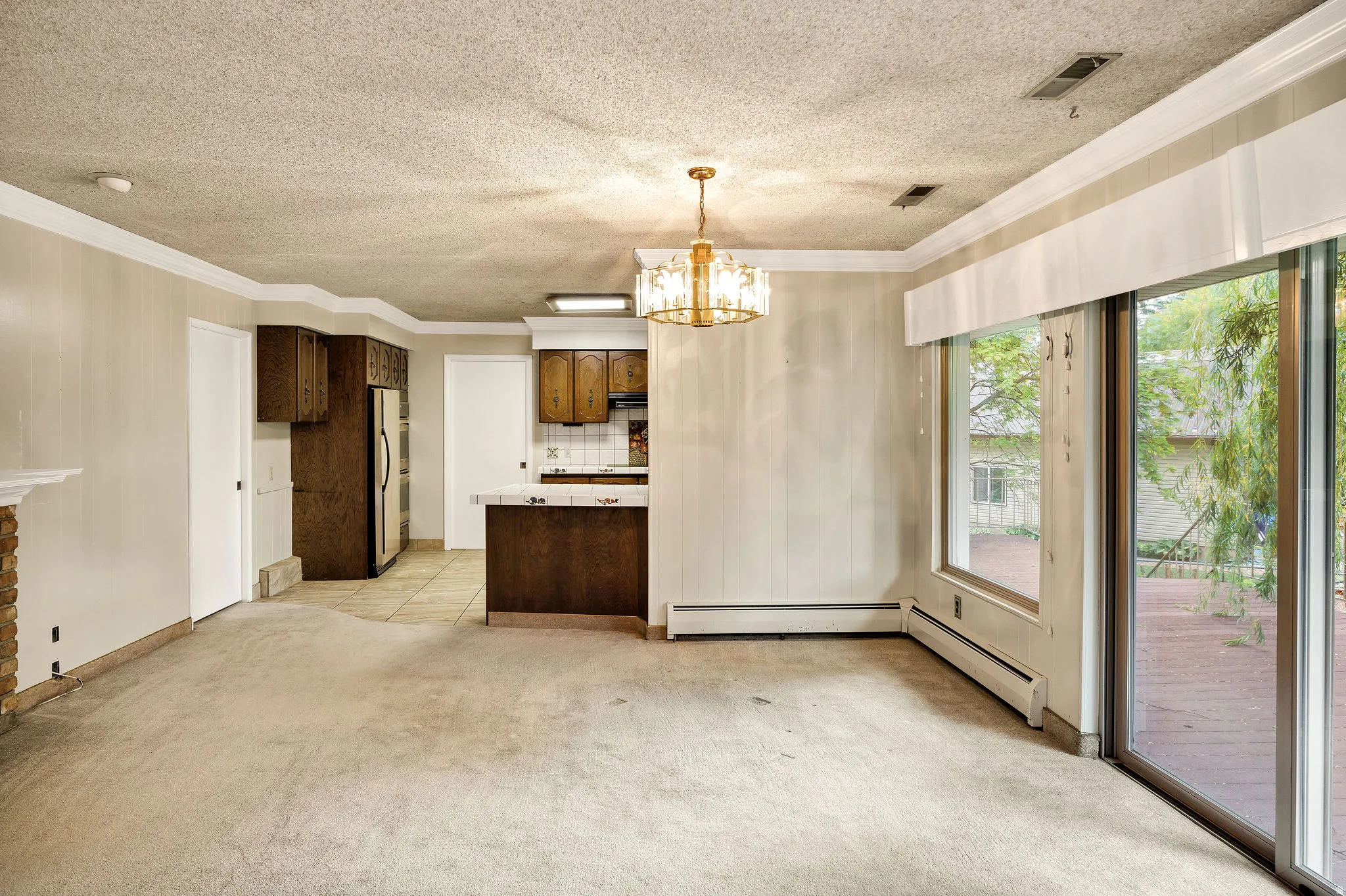 Spacious living area featuring a stone-clad fireplace and sliding glass doors opening to an outdoor deck