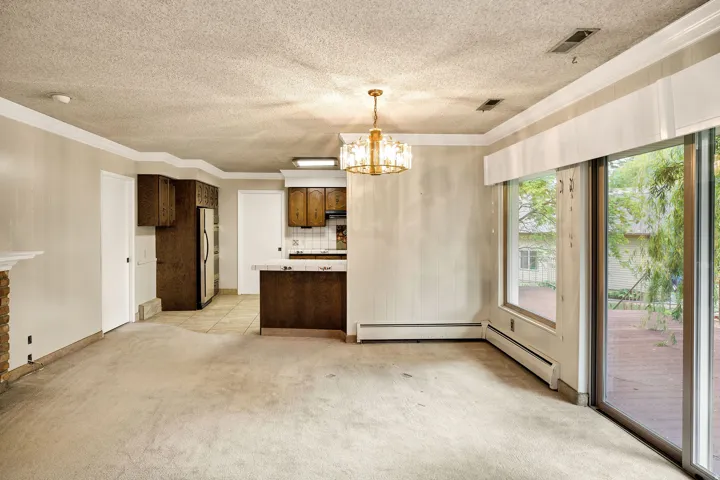 Spacious living area featuring a stone-clad fireplace and sliding glass doors opening to an outdoor deck