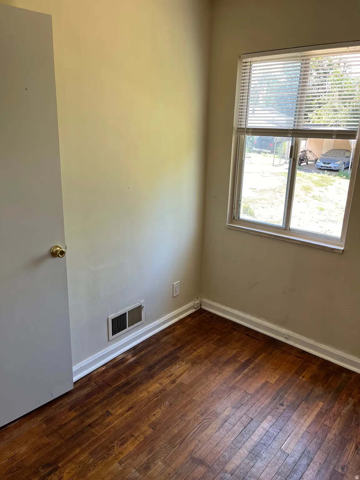Wood-finish flooring with white baseboards and neutral wall tones