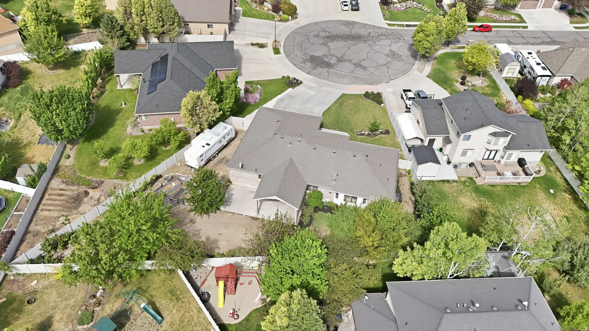 Single-story residence with an attached garage, featuring a paved driveway and mature landscaping