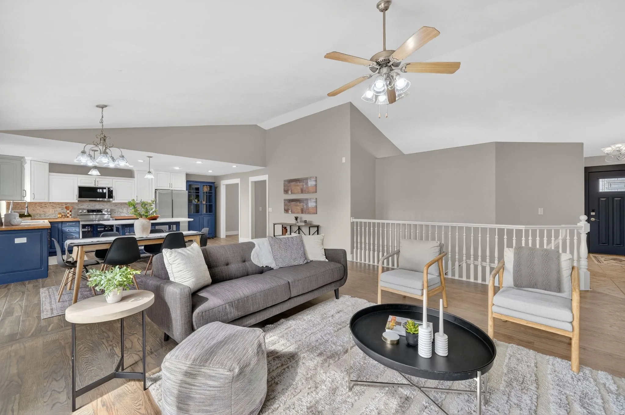 Open-concept living area with vaulted ceilings and wood-finish flooring