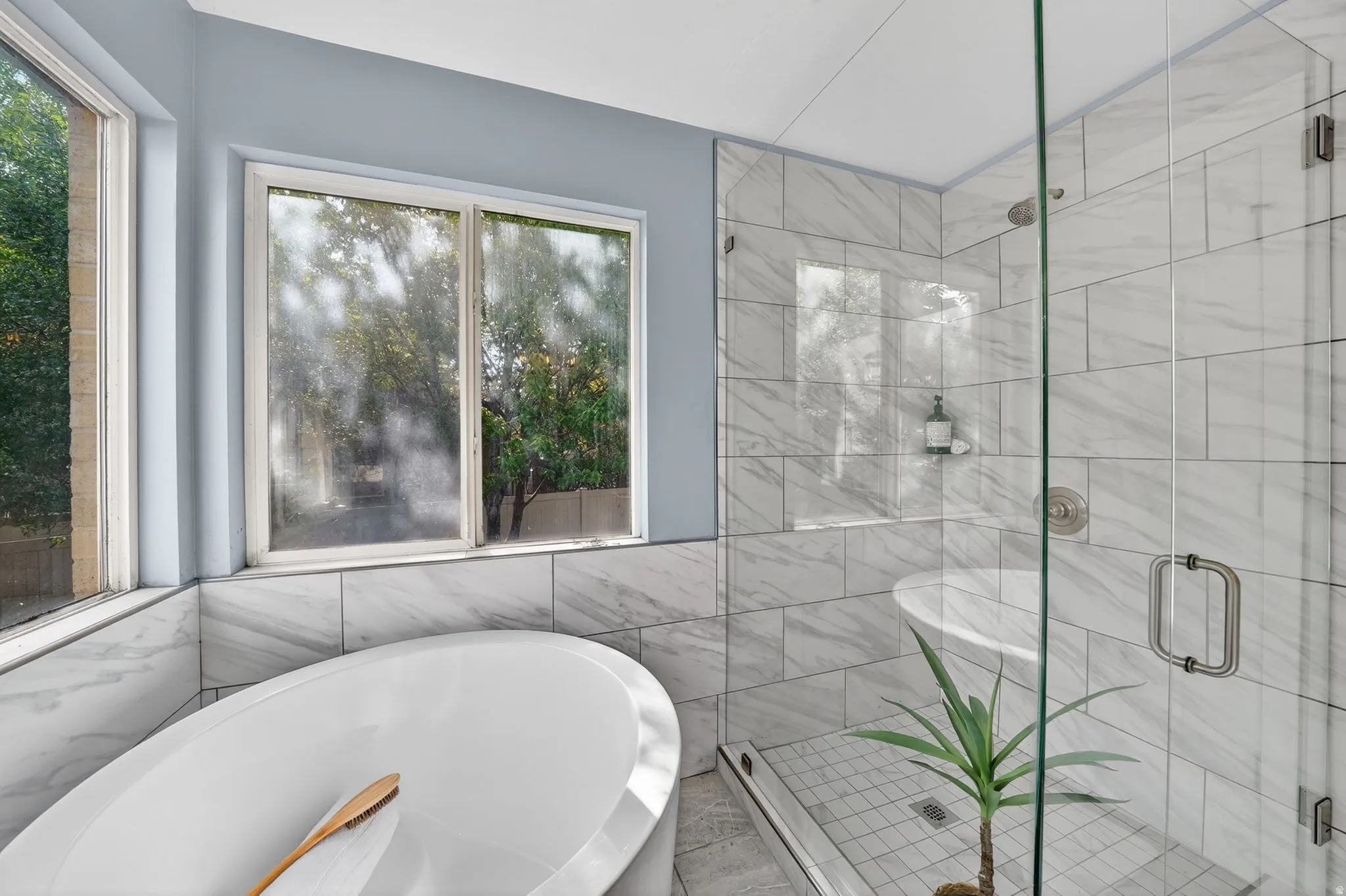 Freestanding soaking tub with surrounding tiled wall