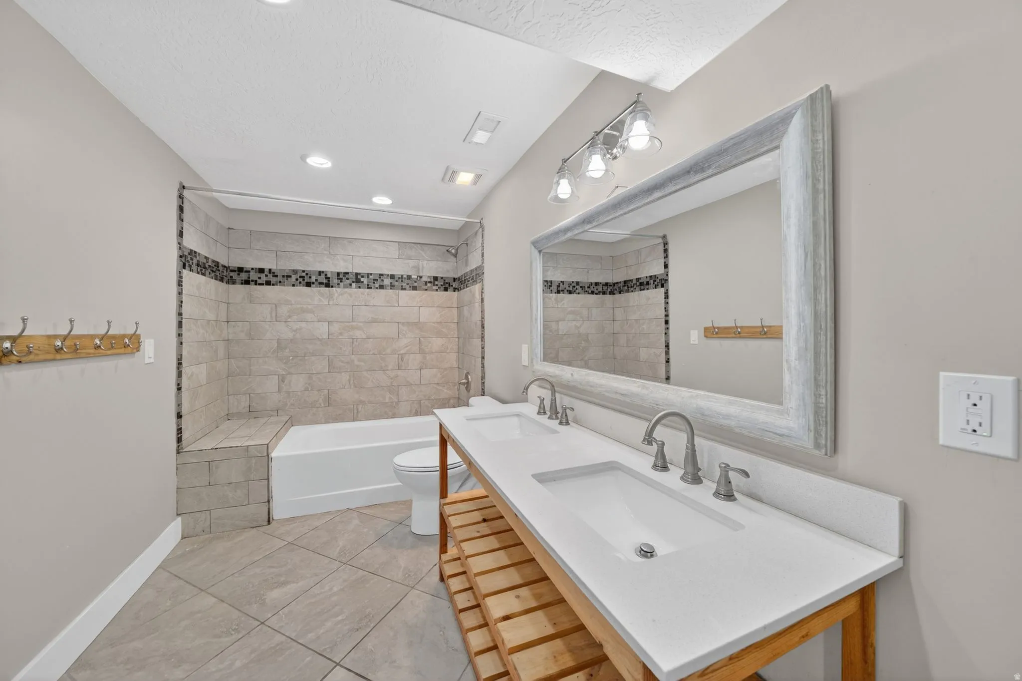 Bathroom featuring a dual vanity with undermount sinks, a white countertop, and brushed nickel fixtures