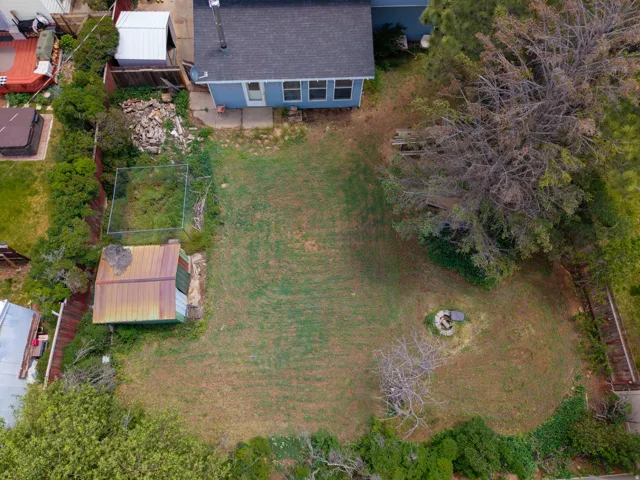 Expansive grassy yard area with a circular fire pit