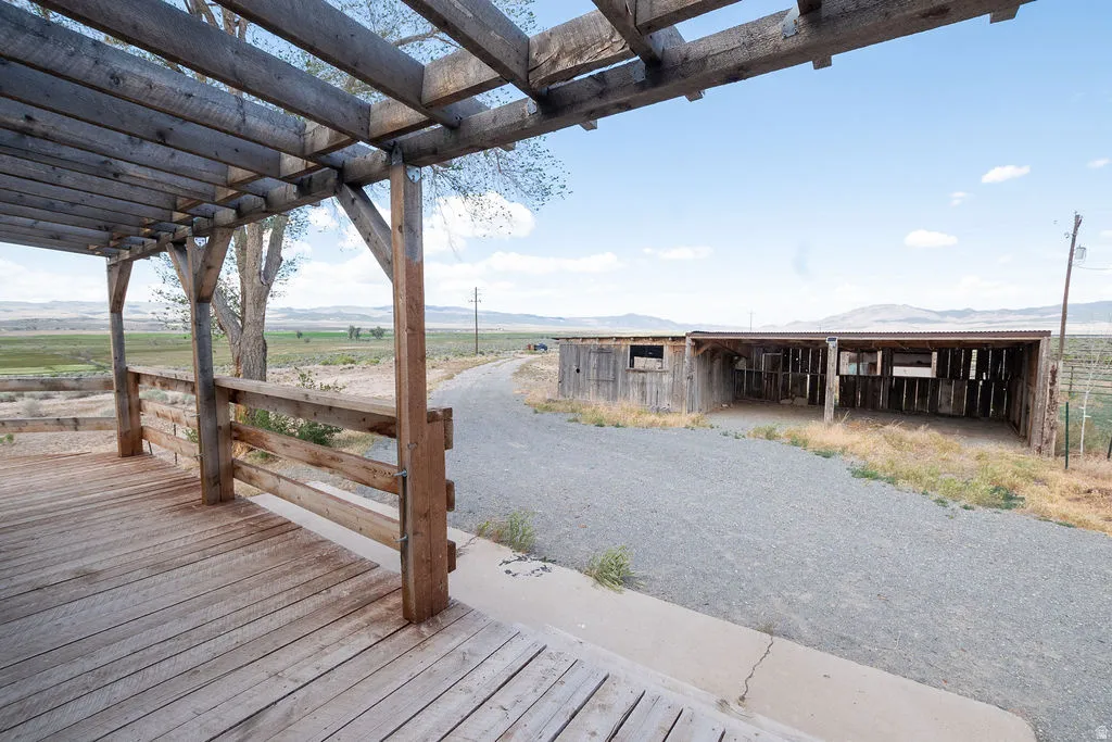 Expansive wood deck with an overhead pergola and railing