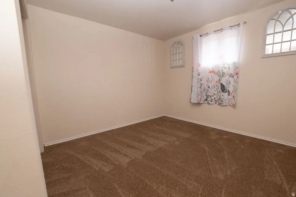 Neutral-toned walls complement the brown carpeted flooring