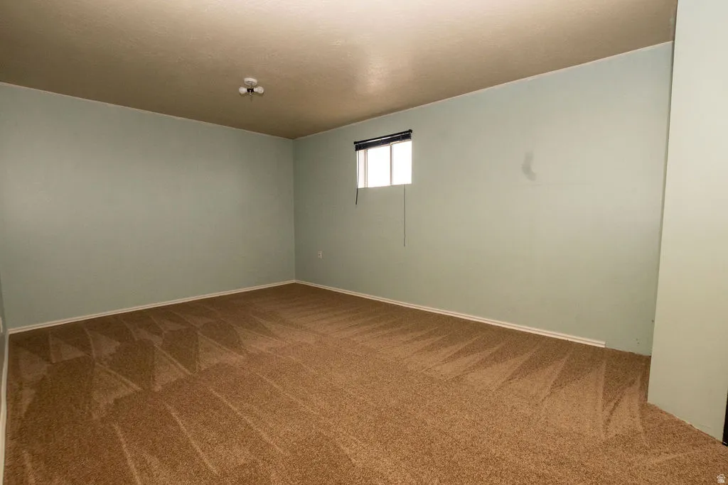 Expansive room featuring wall-to-wall carpeting and light blue painted walls