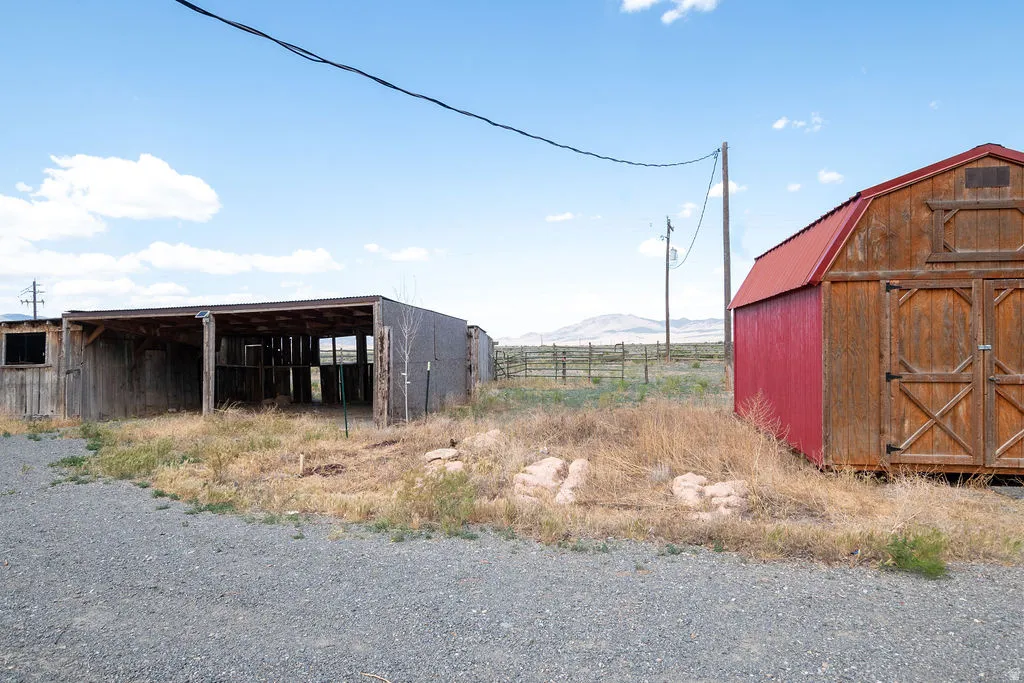 Red-sided storage shed featuring natural wood double doors and a red metal roof