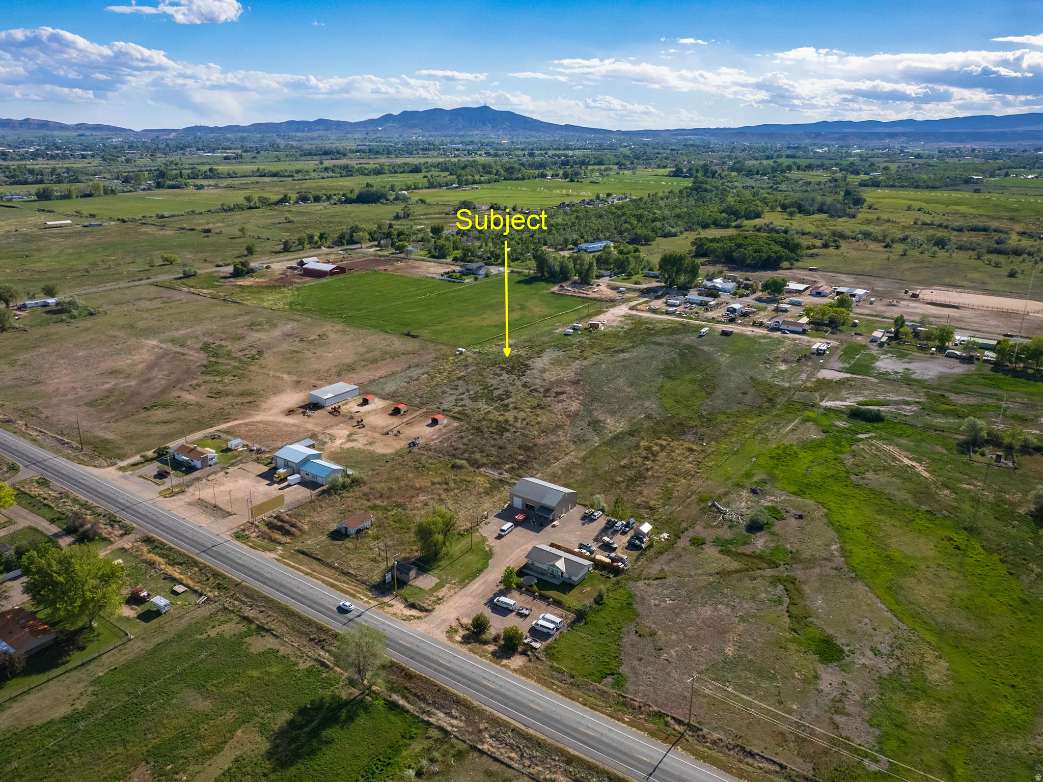 Expansive acreage featuring mixed terrain, partial tree coverage, and distant mountain scenery
