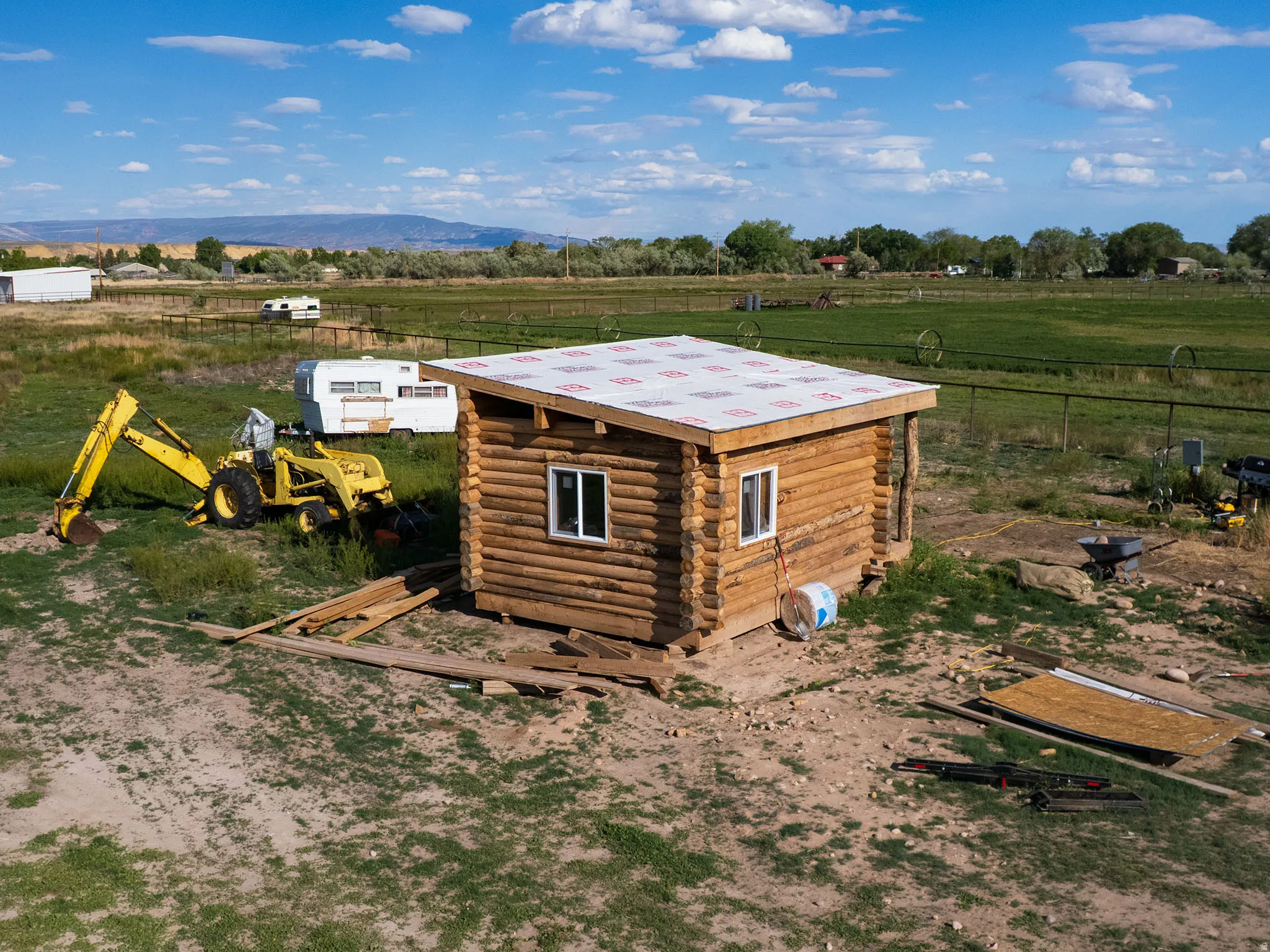 Log cabin structure featuring a newly installed roof underlayment and dual-pane windows