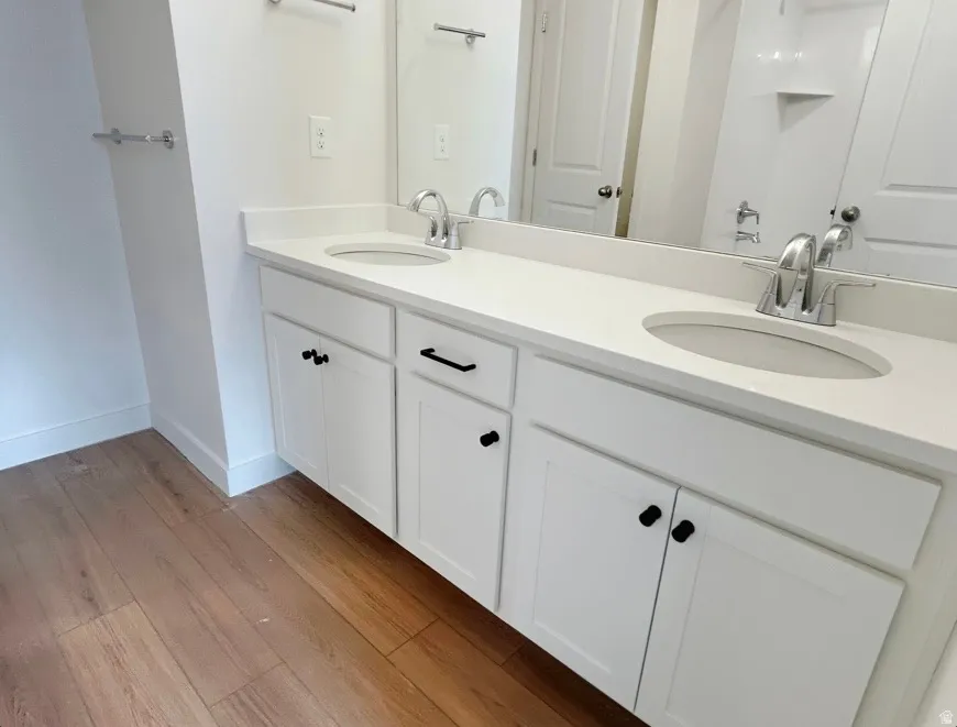Double vanity with white cabinetry and matte black hardware, featuring integrated sinks and polished chrome faucets