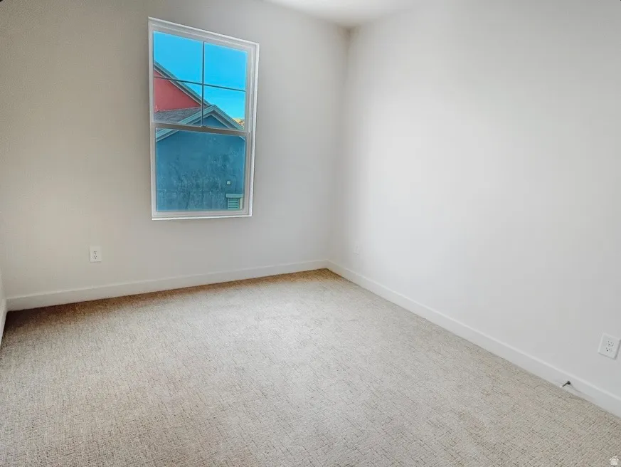 Bright interior room featuring neutral-toned carpet flooring and white painted walls
