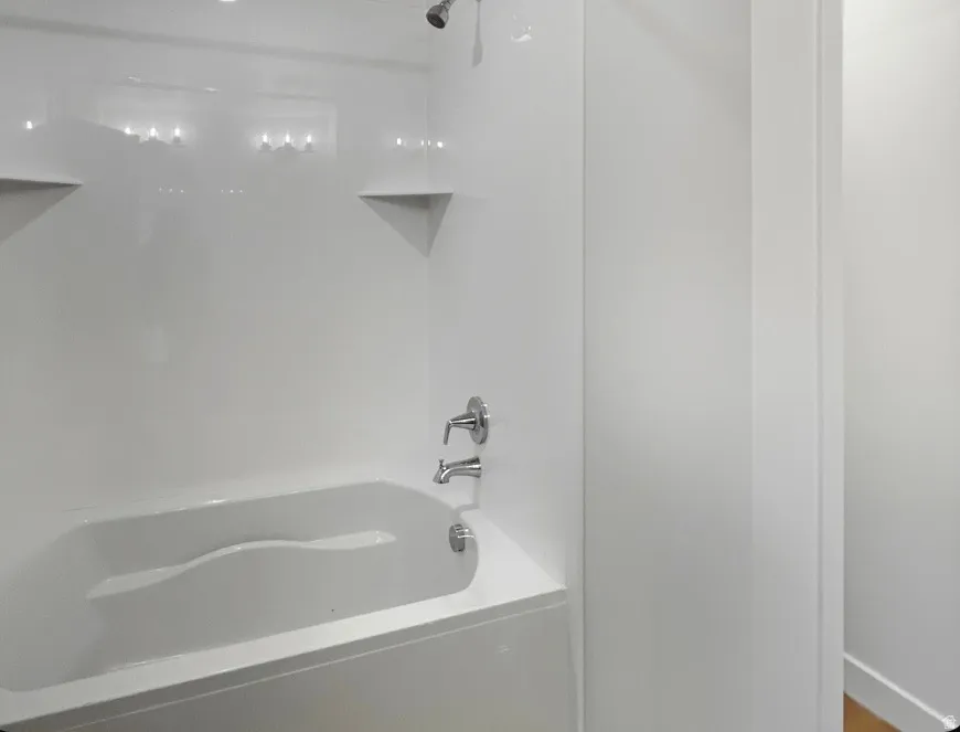 White tub and shower combination with chrome fixtures
