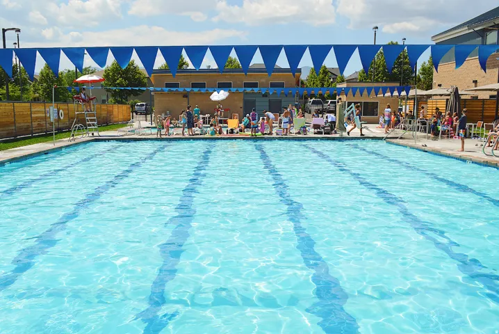 Inviting outdoor swimming pool featuring lane markers, concrete decking, and perimeter fencing