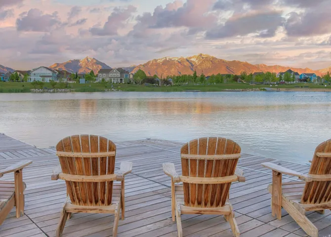 Expansive lakefront setting featuring a wooden dock and distant mountain range