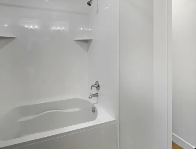 White tub and shower combination with chrome fixtures