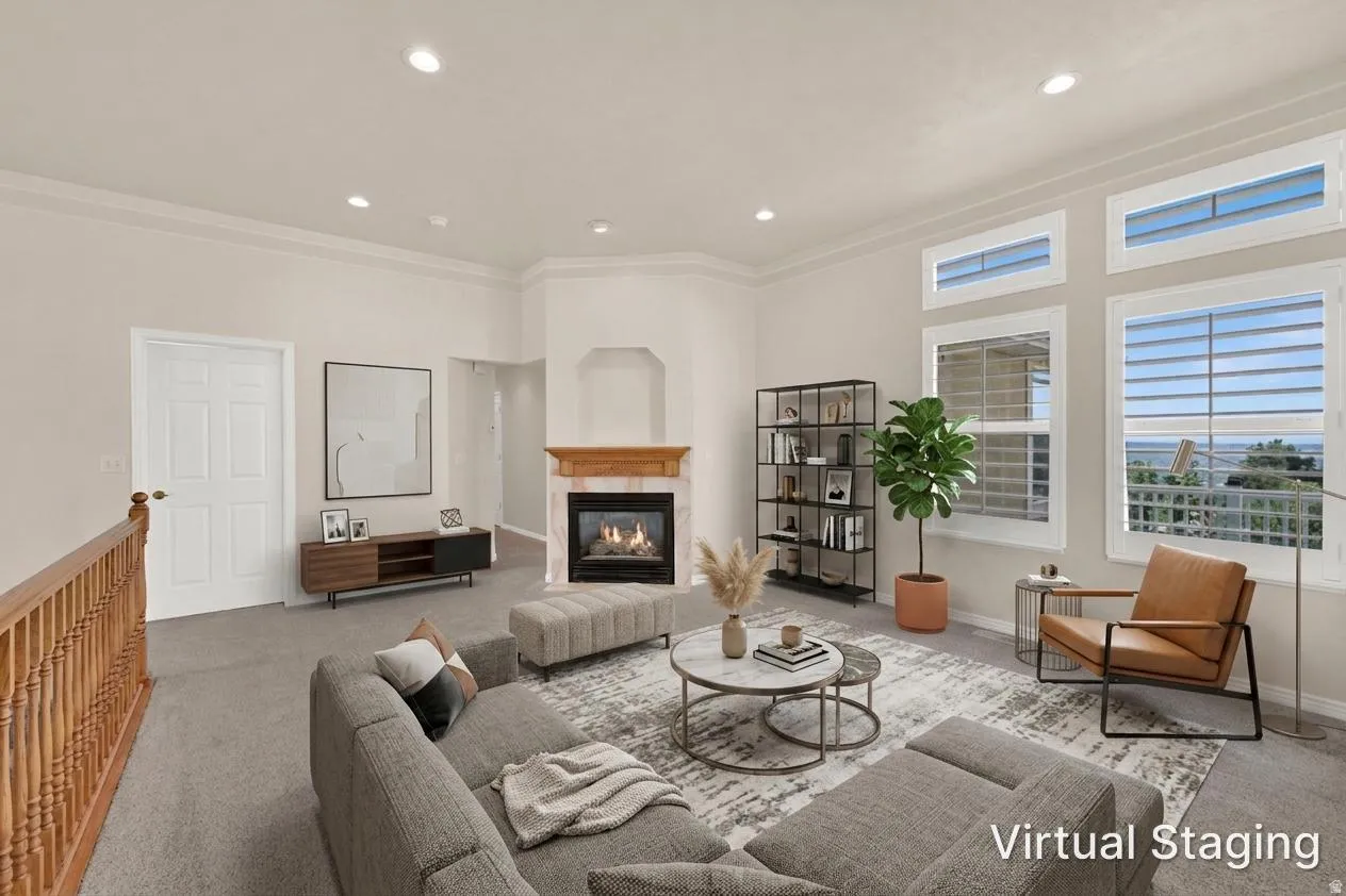Living area featuring a fireplace with a wood mantel, multiple windows, recessed lighting, and crown molding
