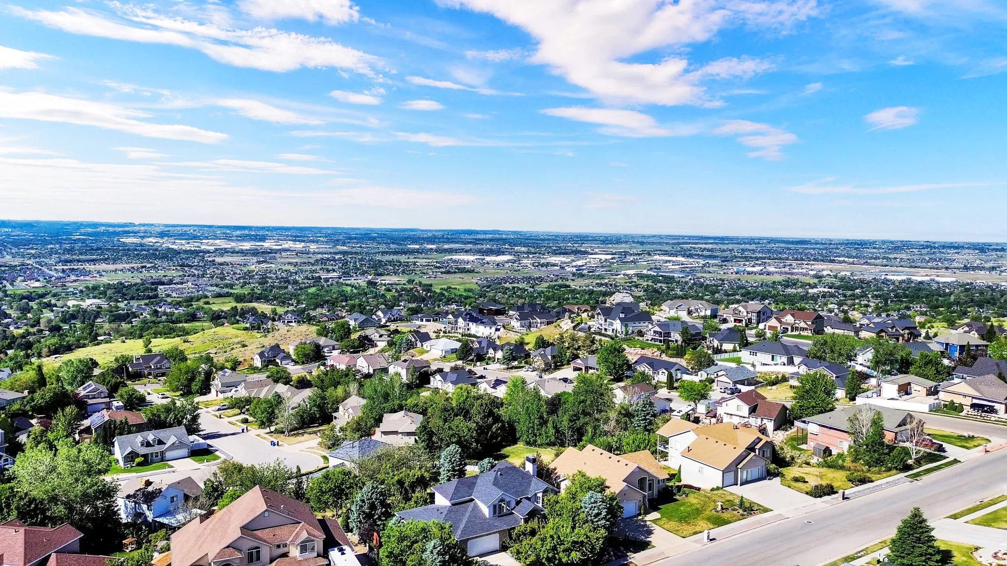 Expansive residential area featuring a variety of architectural styles, mature trees, and paved streets