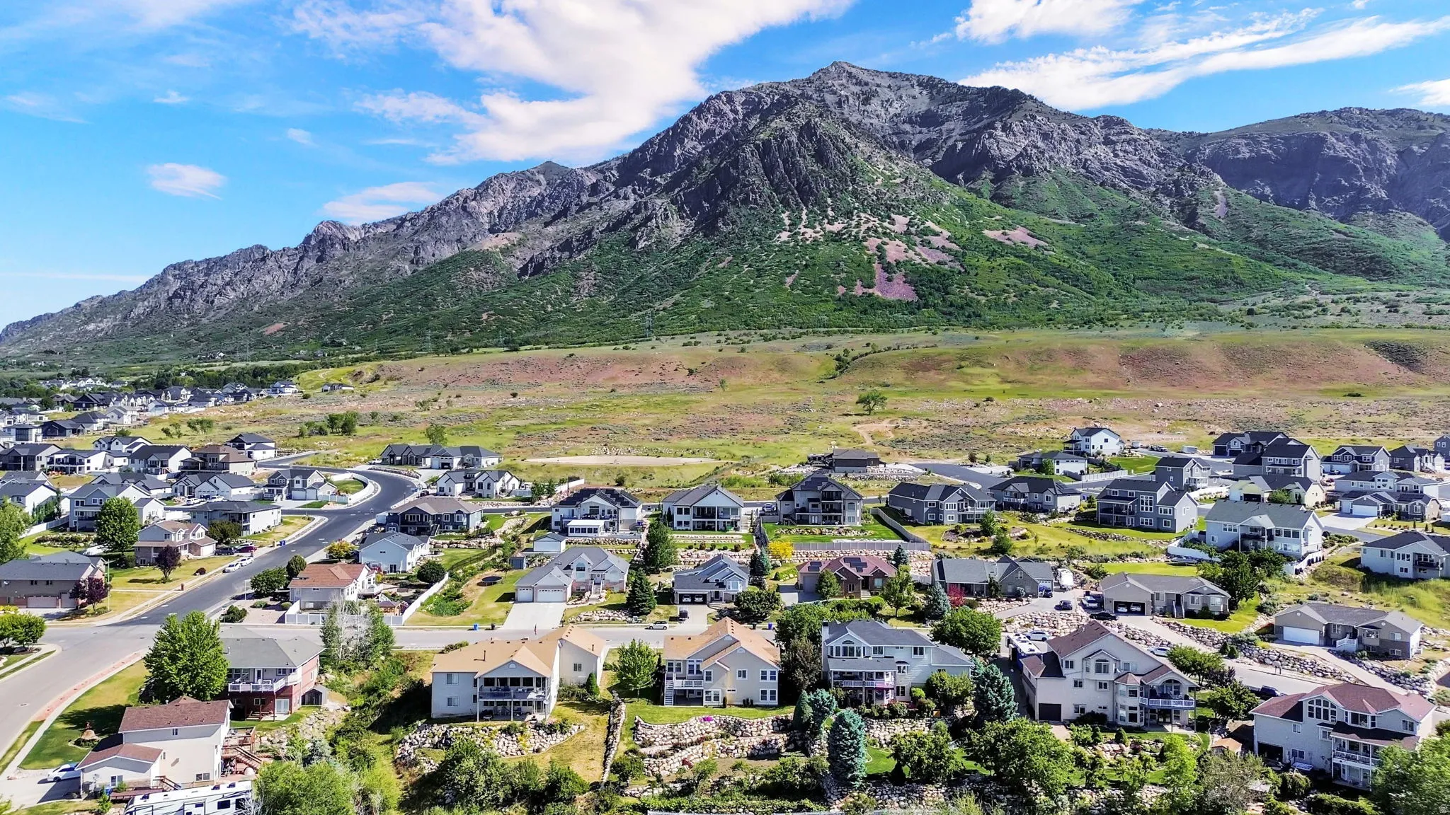 Residential neighborhood featuring a mountainous backdrop, paved streets, and a variety of architectural styles