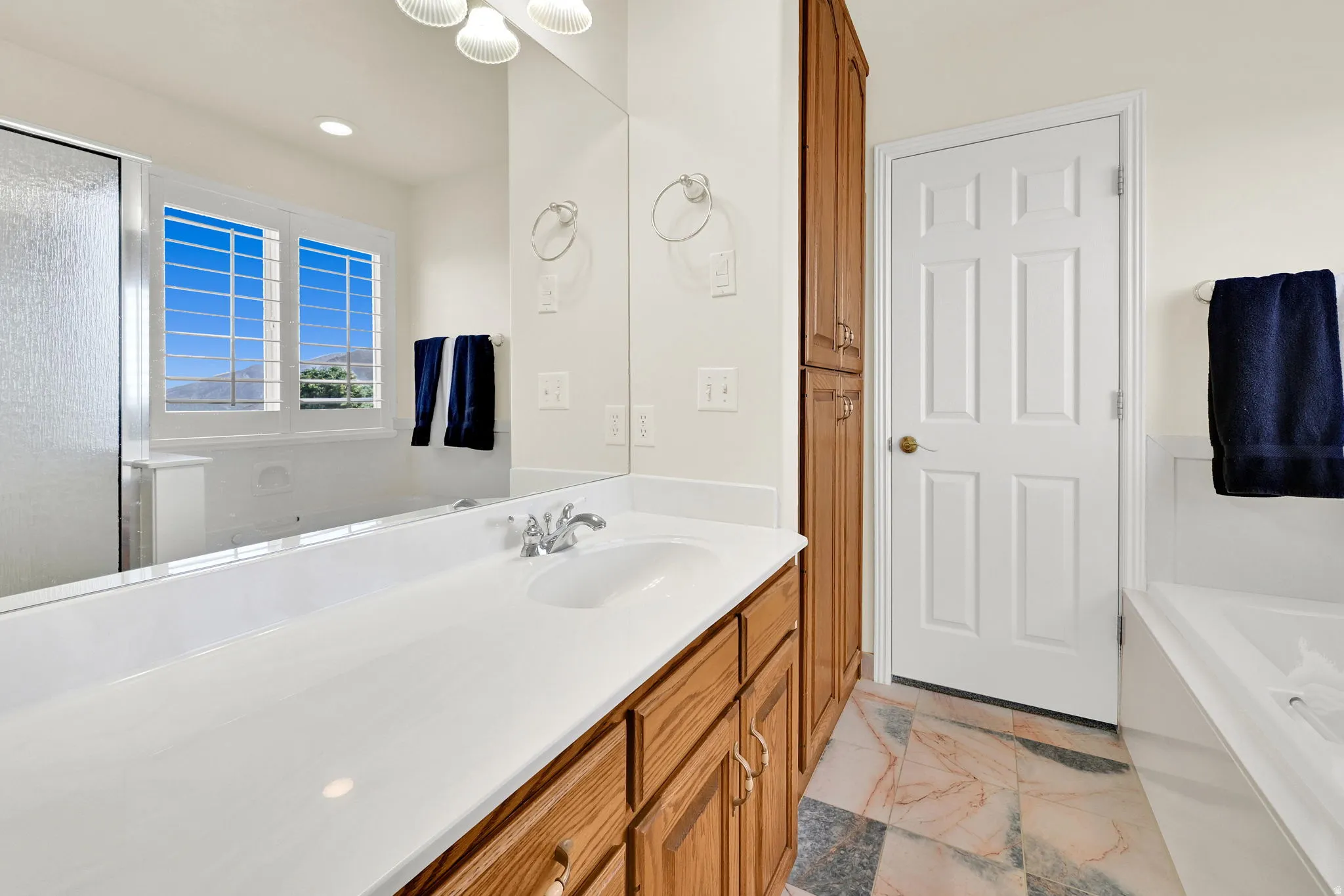 Bathroom vanity featuring a large mirror, integrated sink, and chrome faucet
