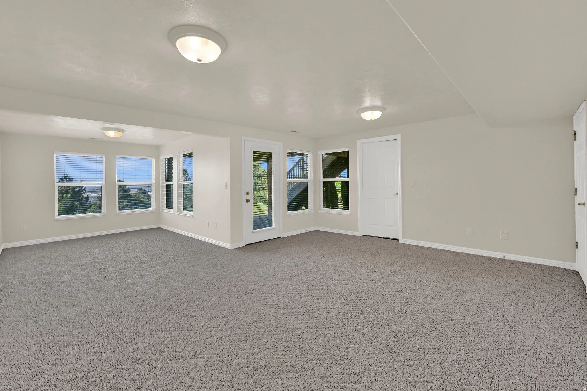 Spacious room featuring neutral carpeting and light-toned walls