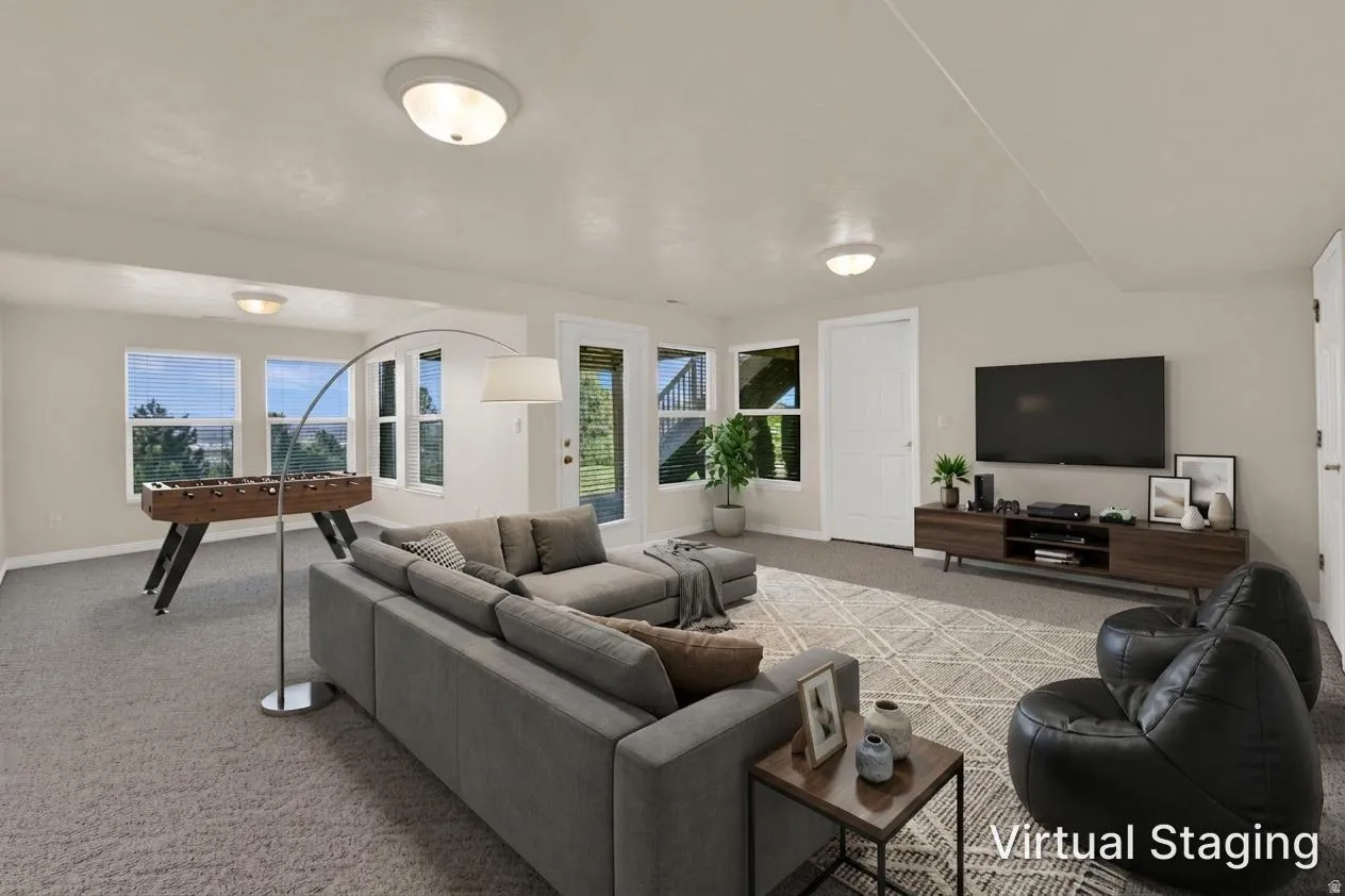 Spacious lower-level living area with light beige walls and recessed lighting