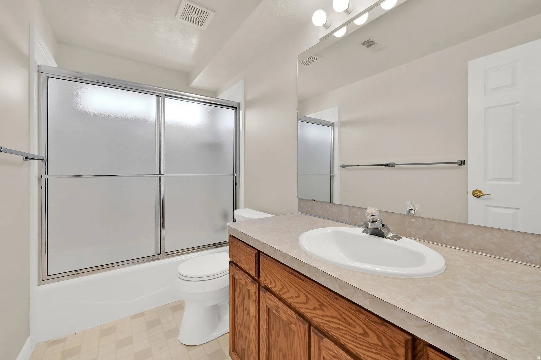 Bathroom featuring a single vanity with wood-finish cabinetry and a laminate countertop