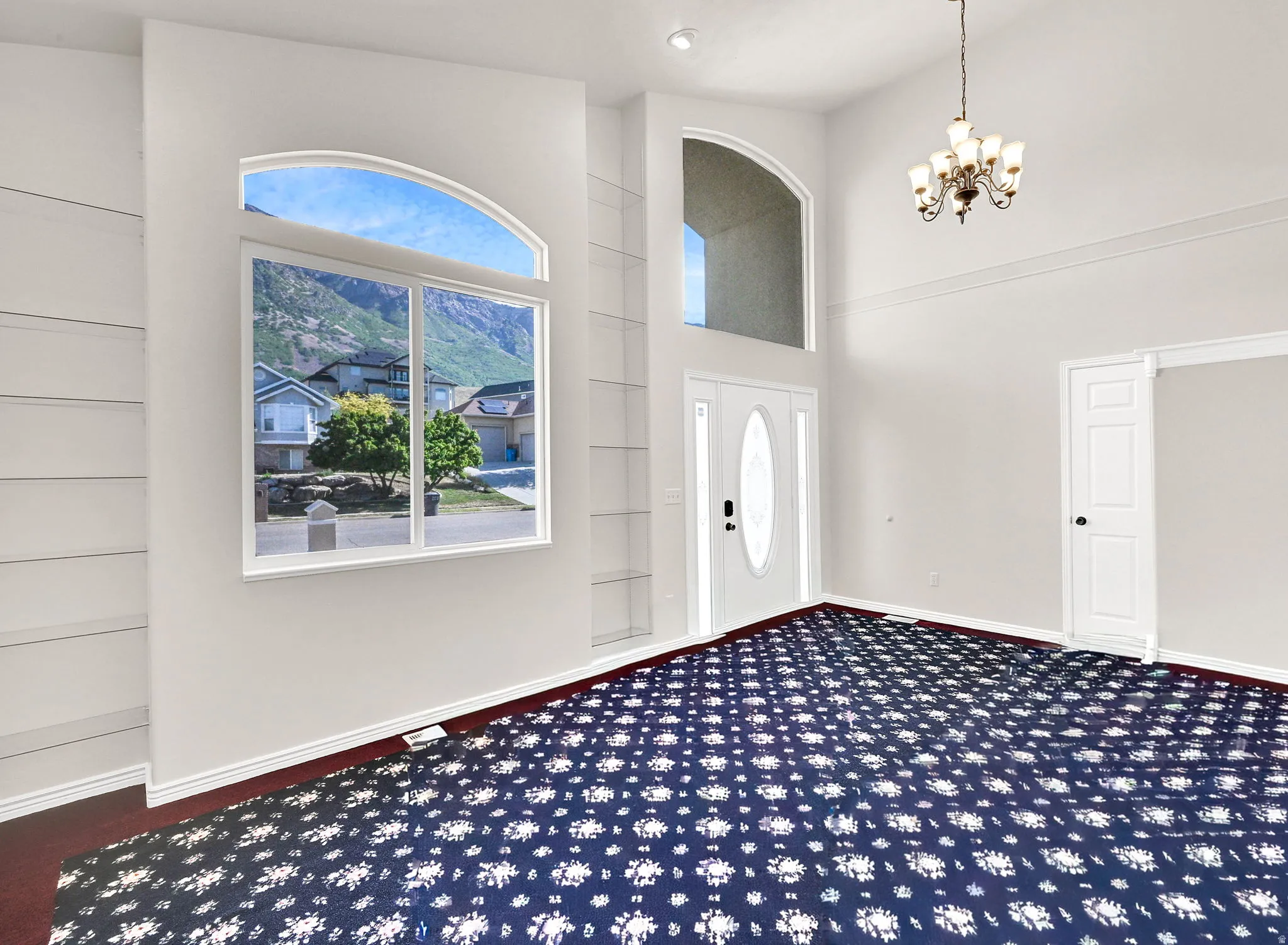Two-story entryway with vaulted ceilings and an arched transom window