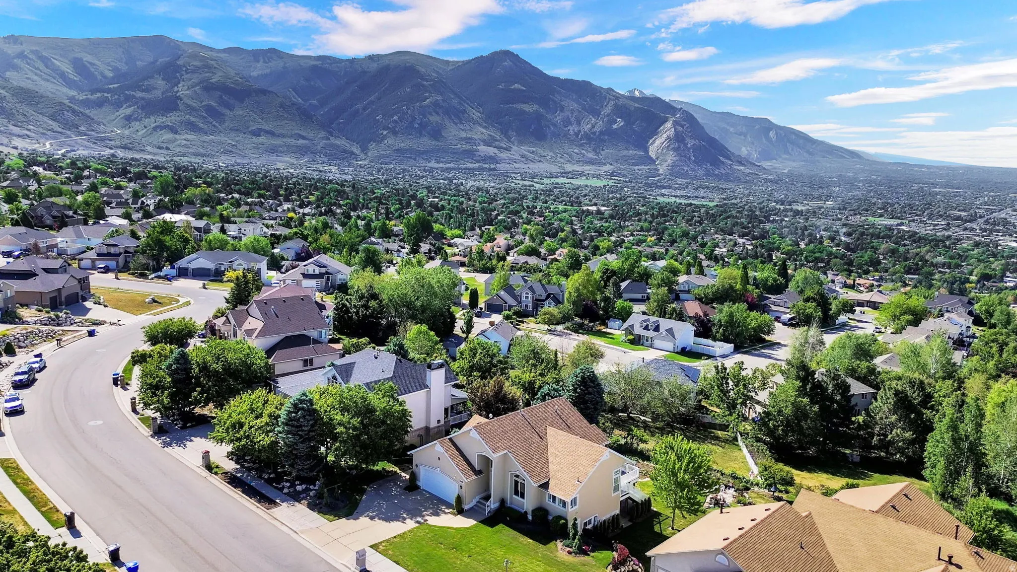Expansive residential area with mature landscaping, surrounded by mountainous terrain