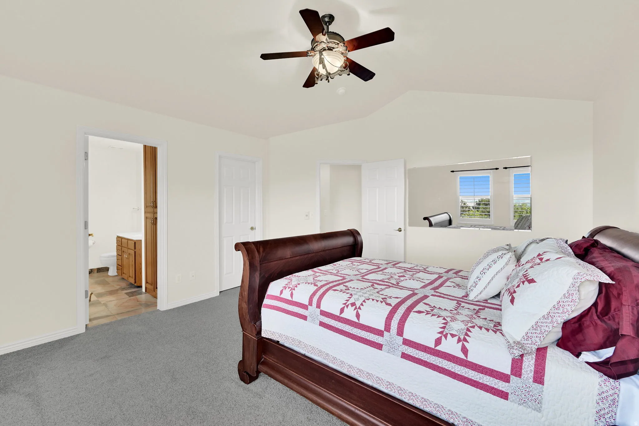 Spacious room with vaulted ceilings and gray carpet flooring