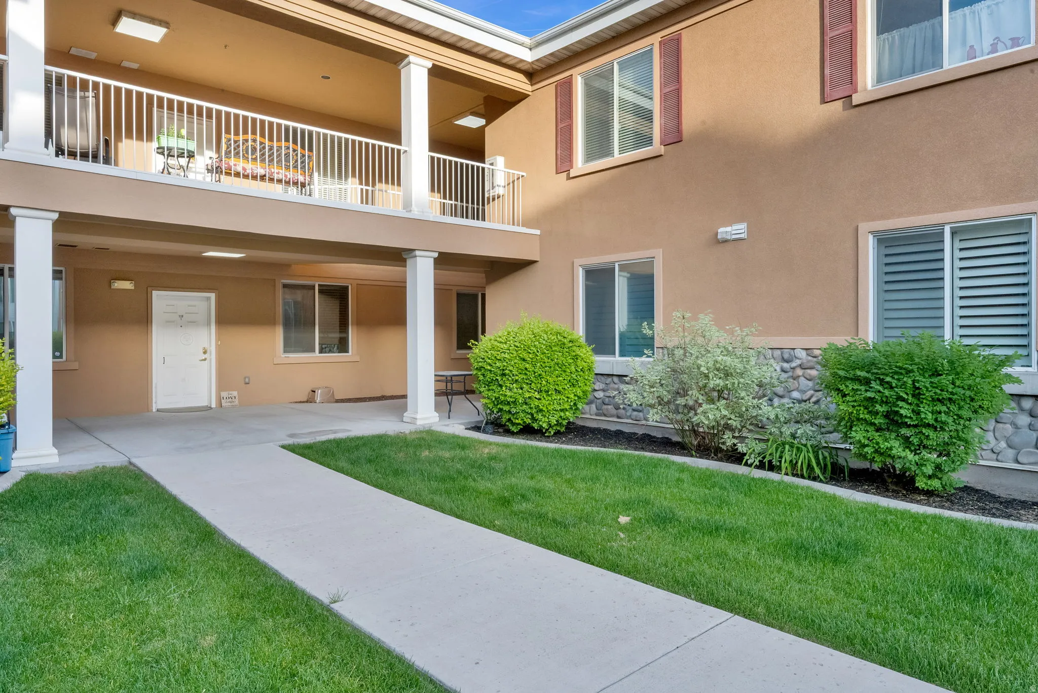 Exterior building with stucco finish, stone accent detailing, and multiple windows