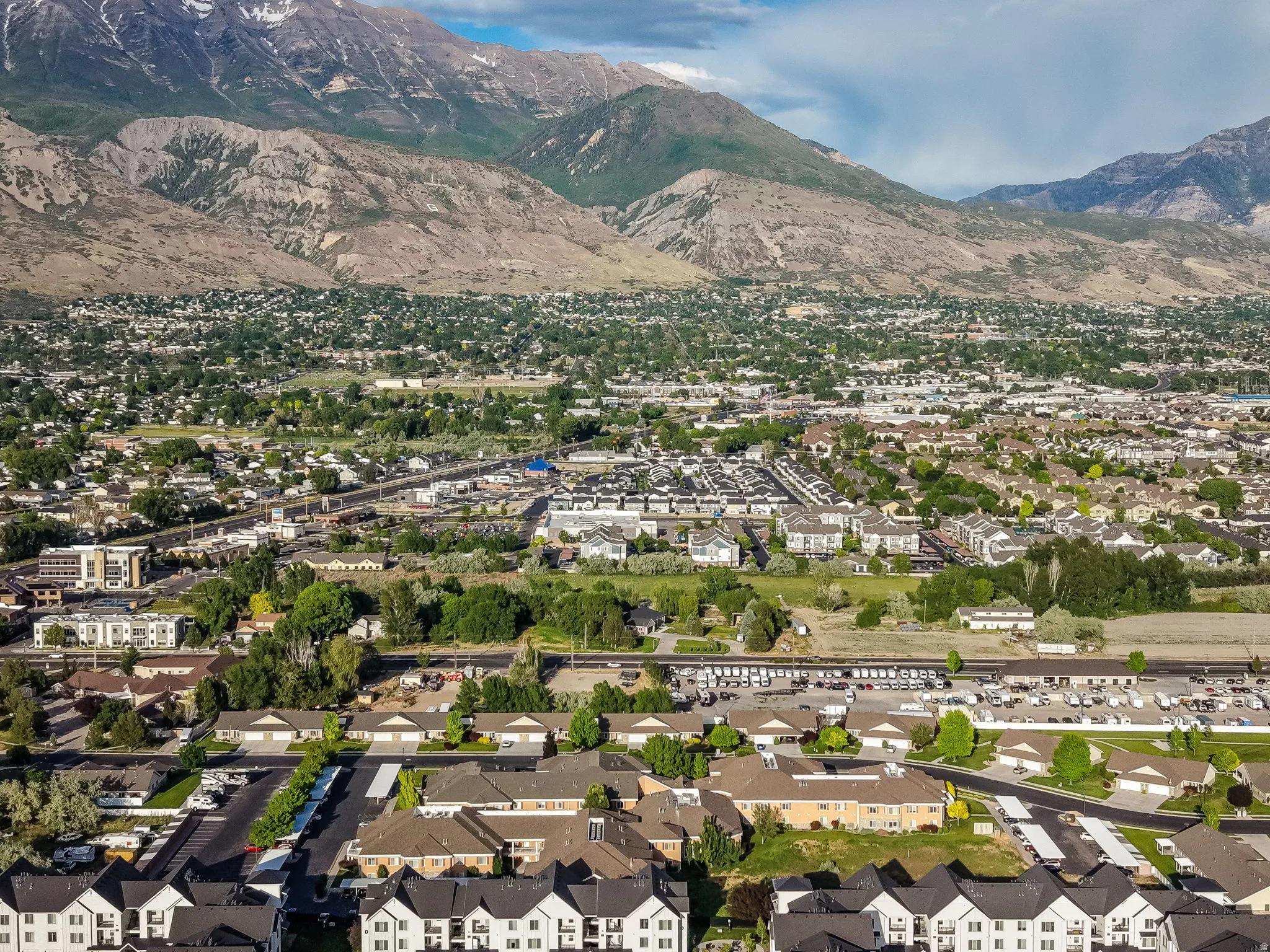 Mountainous terrain with snow-capped peaks provides a natural backdrop for this community featuring a mix of multi-story residences and single-story structures