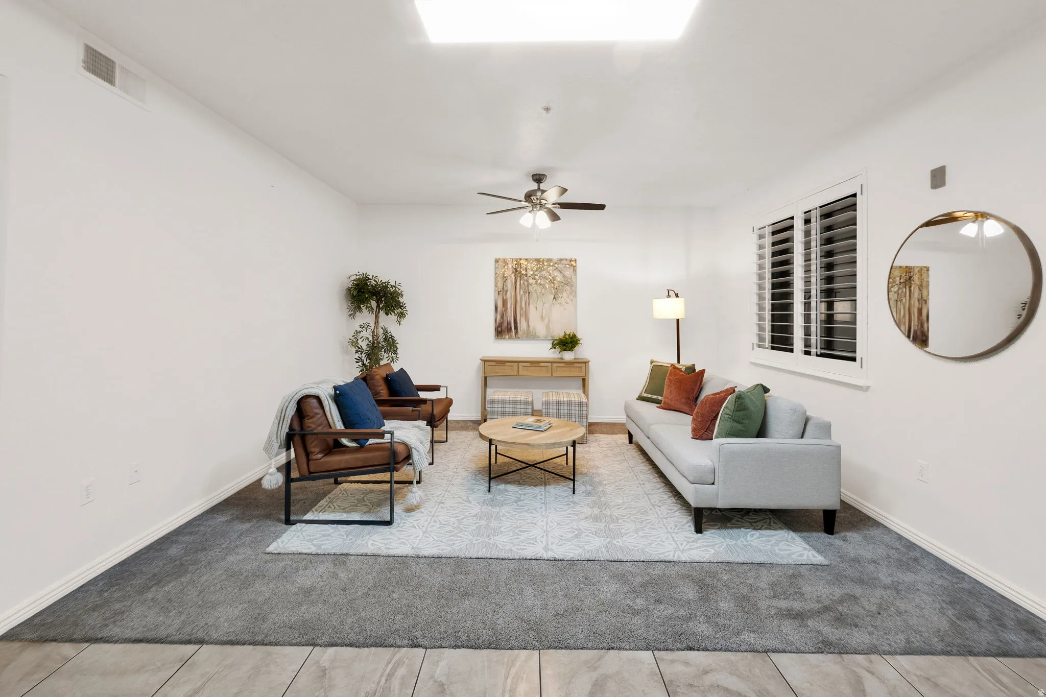Living area featuring neutral wall tones, recessed lighting, a ceiling fan, and window shutters
