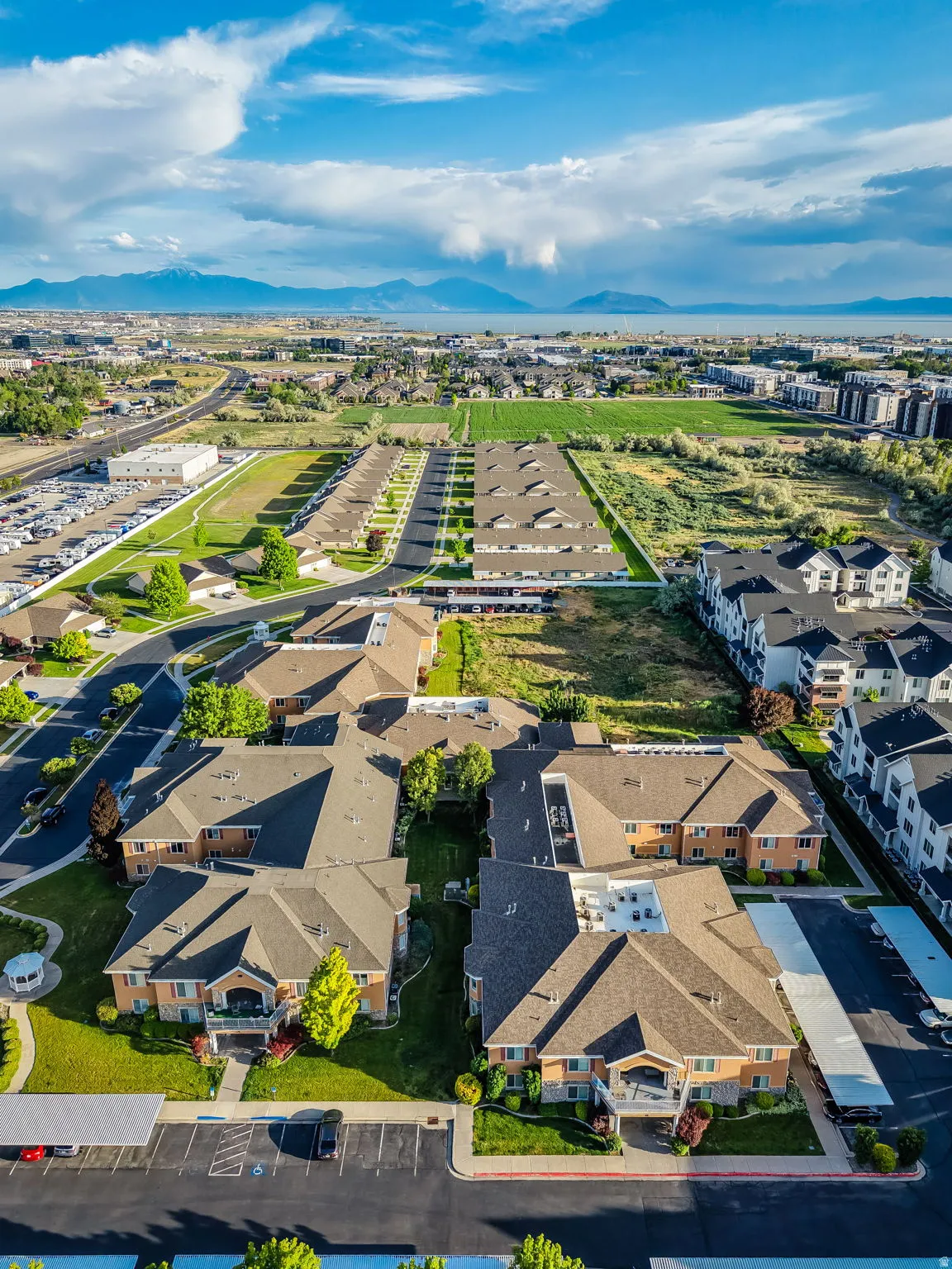 Aerial perspective showcasing multiple residential buildings with pitched roofs, surrounded by landscaped greenspaces